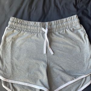 Grey track shorts with white trimming.